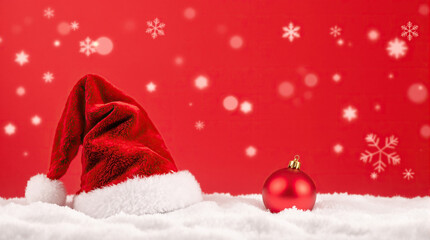 Holiday scene with hat and ornament over snowy red background