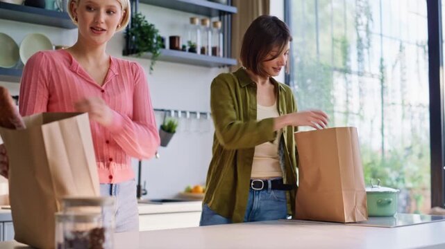 Lgbt couple putting shoppings kitchen table arrived from grocery store closeup