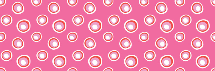 Playful colorful circles seamless pattern on pink background