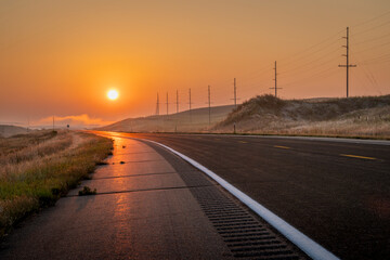 Obraz premium foggy sunrise over a highway in Nebraska Sandhills near Mullen