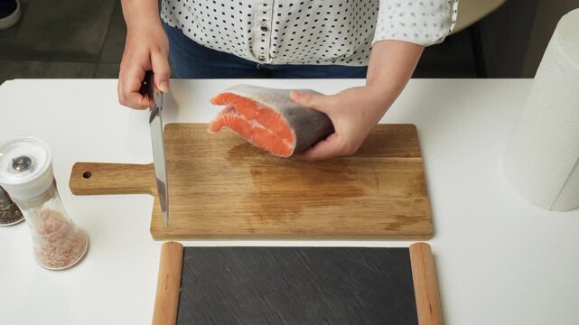 Female hands preparing the trout fish for cooking at home kitchen. Concepts of healthy eating and seafood