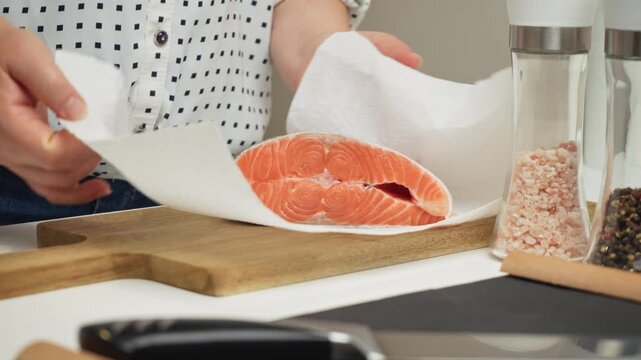 Female hands preparing the trout fish for cooking at home kitchen. Concepts of healthy eating and seafood