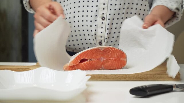 Female hands preparing the trout fish for cooking at home kitchen. Concepts of healthy eating and seafood
