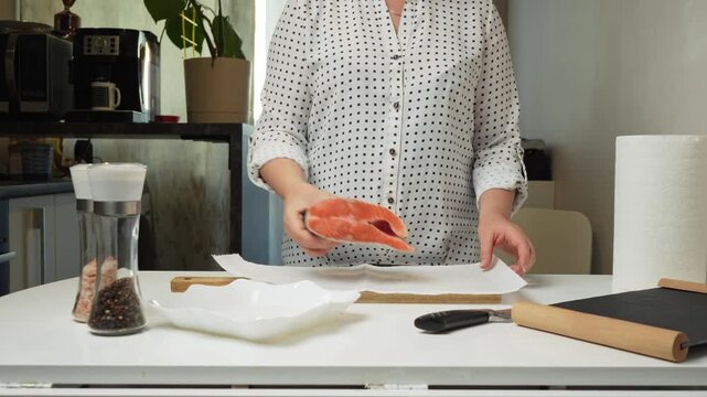 Female hands preparing the trout fish for cooking at home kitchen. Concepts of healthy eating and seafood
