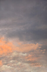 Vertical dramatic sunrise sky with peach  orange  and grey  clouds . Sky landscape  in the early morning .