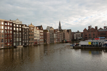 Beautiful panarama view of old Amsterdam buildings on the canal under blue sky 
