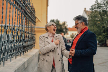 Senior couple laughing together while walking in the city