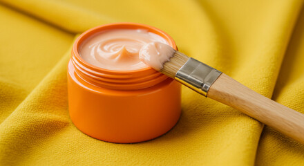 Luxurious cream in an orange jar with a brush, perfect for beauty routines, spa treatments, and skincare promotions.