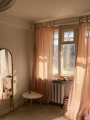 Cozy home interior with mirror and window curtains in sun light 