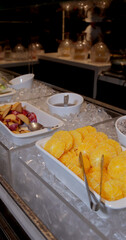 Fresh fruit display on ice at buffet, featuring sliced oranges and plums, in luxury restaurant setting. Vibrant colors highlight freshness and abundance, perfect for hospitality themes. Vertical