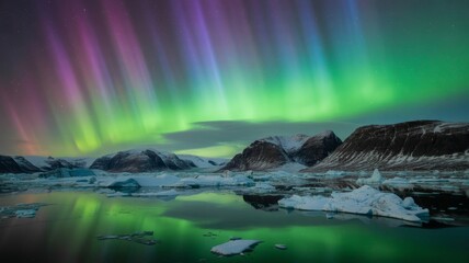 Naklejka premium Spectacular aurora borealis over snowy mountains and icy waters in iceland
