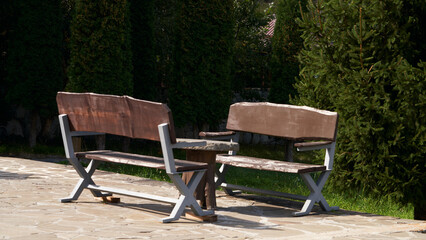 Fototapeta premium Outdoor recreation. Outdoor furniture set (two benches and a table) made of rough wood on a metal frame.