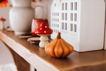 Decorative autumn shelf with charming mushroom and pumpkin figurines in cozy indoor setting