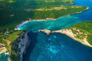 Cinematic aerial landscape shots of the beautiful island Diamond beach of Nusa Penida. Huge cliffs by the shoreline and hidden dream beaches with clear water.