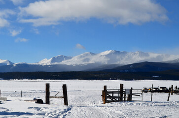 Fenced Area with a Snow Covered Field and Mountains
