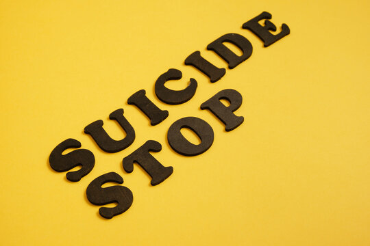 stop suicide concept, inscription made of wooden letters on a bright background