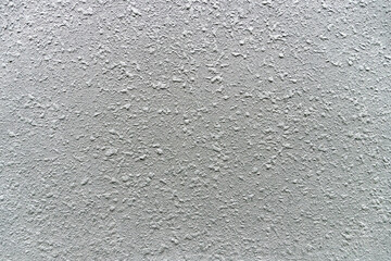 Stylish abstract white cement wall texture with particles in the form of drops. Close-up background for design. Top view.