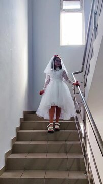 A girl in a white dress and a veil, the image of a scary bride, a zombie,walks around the house, on Halloween