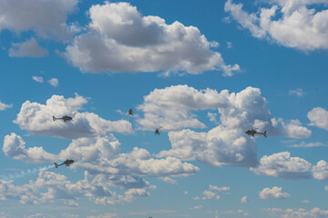 Five helicopters flying in formation in the sky, creating an impressive aerial display.