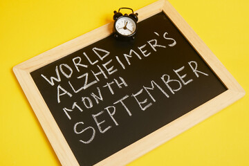 chalk lettering september alzheimer awareness month, brain decline concept yellow background