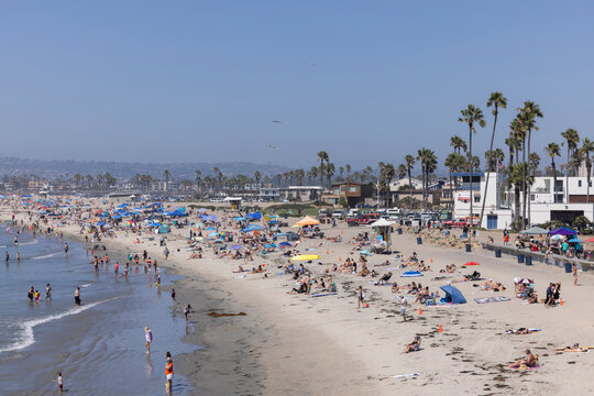 San Diego, California, USA - August 27, 2023: People enjoy the sand and surf of Ocean Beach on a hot day.