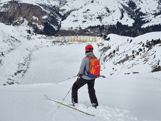 Single skier in the backcountry overlooking a water reservoir