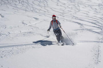 Single female skier making tracks in fresh powder snow