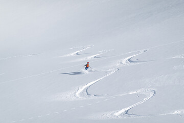 Single offpiste skier making fresh tracks in powder snow