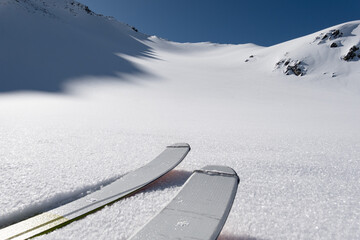 Single ski tourer ascending towards a snow covered ridge