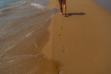 Woman walking on the beach with footprints in the sand, Thailand, Corfu Greece.