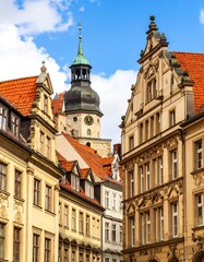 Fototapeta premium European city street scene with historic buildings and a tall tower