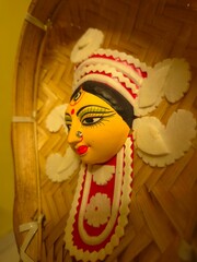 handcrafted wall hanging depicting the stylized face of Ma Durga, created for Durga Puja celebrations.