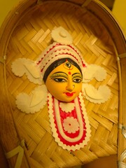 handcrafted wall hanging depicting the stylized face of Ma Durga, created for Durga Puja celebrations.