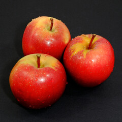 Fresh red apples together on black background close up view