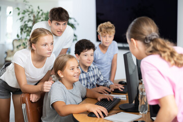 Group of children students learning to use computer in classroom