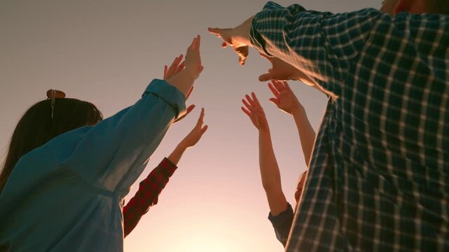 Team spirit men, women unite together. Freedom of young different people joining forces outdoors. Prayer. Many people raised their hands to sky, concept of unity and teamwork. Business people outdoors