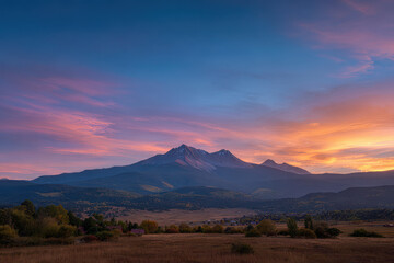 Obraz premium breathtaking sunset unfolds over majestic mountain peaks casting spectacular colors across sky