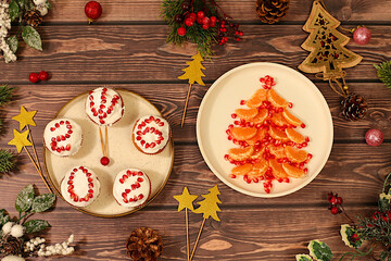 Winter background for greeting card. Curd muffins with glazed pomegranates with numbers 2026 in the form of a clock and a Christmas tree made of tangerines, an idea for decorating food