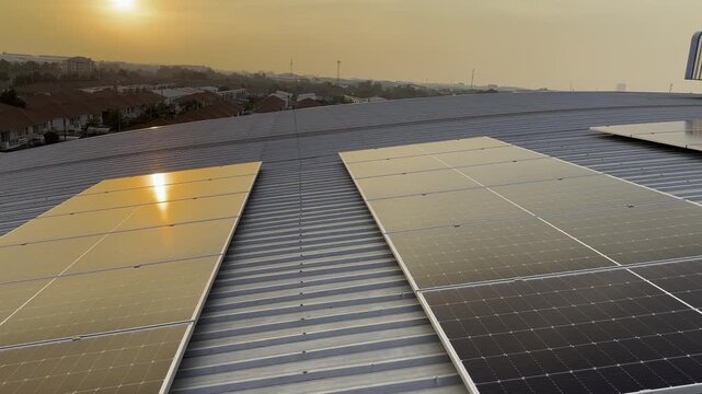 Solar panel installation work in progress at a renewable energy facility. worker in orange safety attire performs maintenance on solar panels located on a rooftop. inspects the photovoltaic cells.