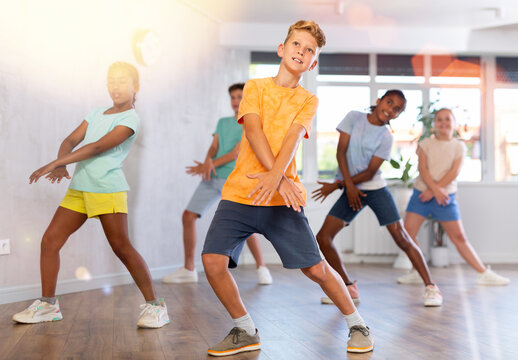 Young boys and girls performing dance with his mates in studio during rehearsal.