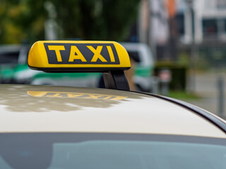Taxi Sign on Top of Vehicle in Urban Setting