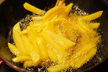 Deep-frying French fries in piping hot oil