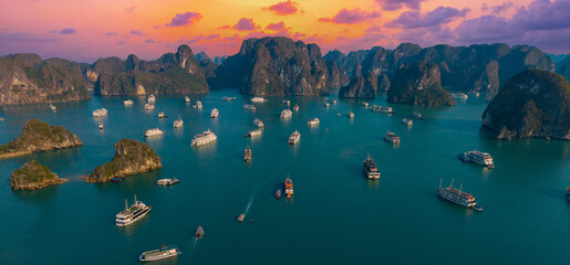 Aerial view of panorama Halong bay at sunset with boats and limestone islands, Vietnam