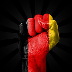 A powerful fist clenched tight, painted in the colors of the German flag, representing German Unity Day backdrop.