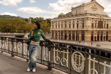 Obraz premium Young woman eating ice cream in front of arriaga theater, bilbao, spain