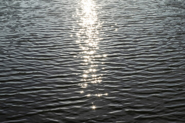 Sun glare on the water's surface, selective focus. Relaxing landscape with sunlight reflections.