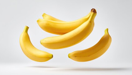 Four ripe bananas levitating against a plain background