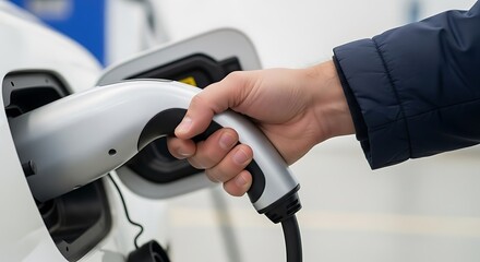 Human Hand Plugging Electric Vehicle Charging Cable into a Car
