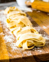 Fresh pasta noodles on a wooden board