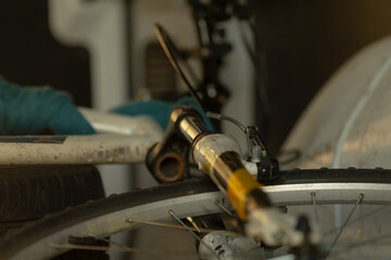A closeup view highlights the skilled bicycle repair process, focusing on precise tool adjustments and essential wheel components in a fully equipped workshop for effective servicing